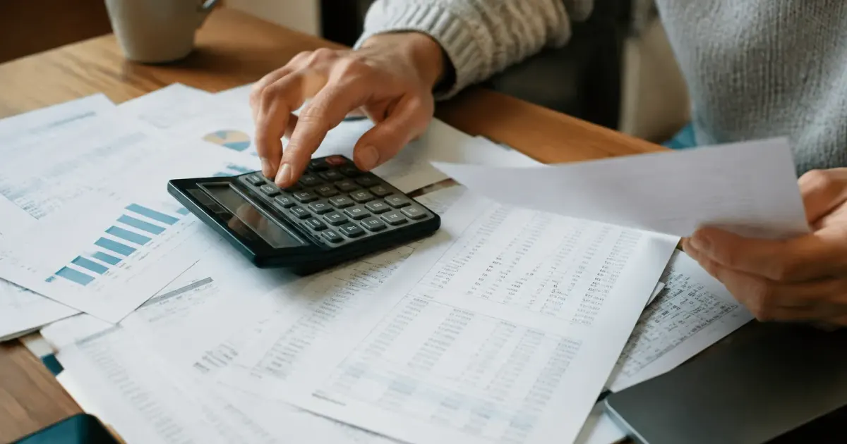 Papiers administratifs avec chiffres et calculatrice visible
