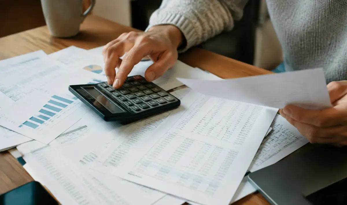 Papiers administratifs avec chiffres et calculatrice visible