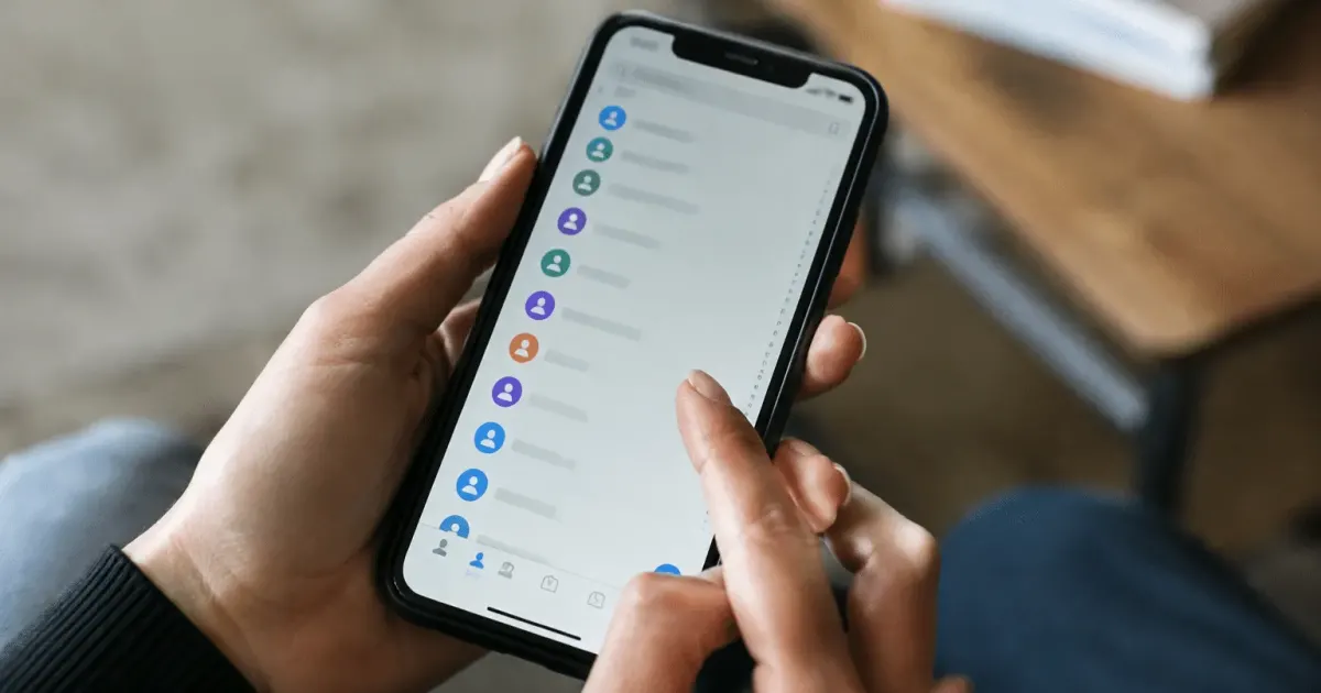 Smartphone affichant liste contacts numeriques sur ecran tactile